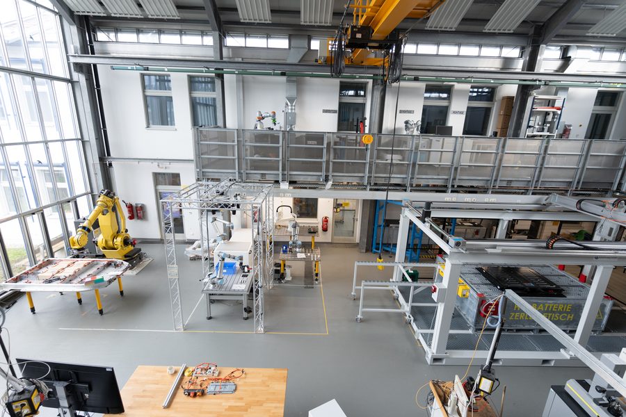 Blick in die Technikumshalle mit Industrieroboter, Zerlegetisch und Arbeitsplätzen.